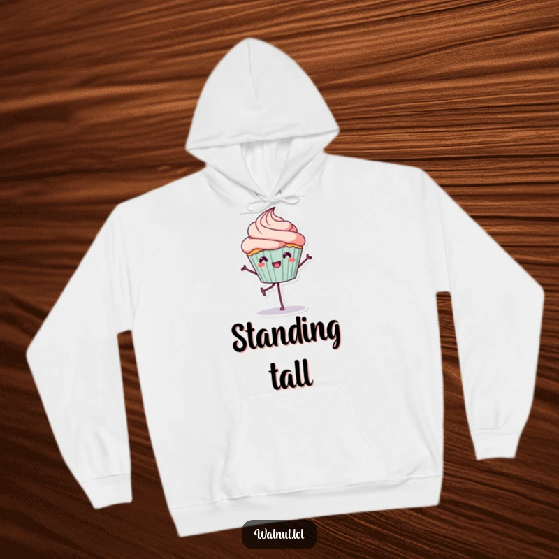 Funny Hoodie: A joyful cupcake character balances on one leg, offering cozy comfort and a dose of sweet, humorous charm.
